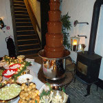 Een gezellig idee om tijdens de kerstborrel met familie, vrienden en collega’s een aardbei of soesje in de chocoladefontein te dompelen.